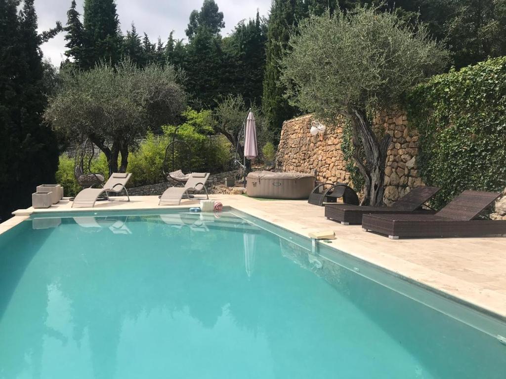 ein großer Pool mit Stühlen und einem Sonnenschirm in der Unterkunft Dieu L'Amour - Galimard in Châteauneuf