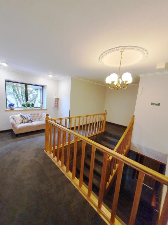 a living room with a staircase and a couch at Fitzherbert Castle Motel in Palmerston North