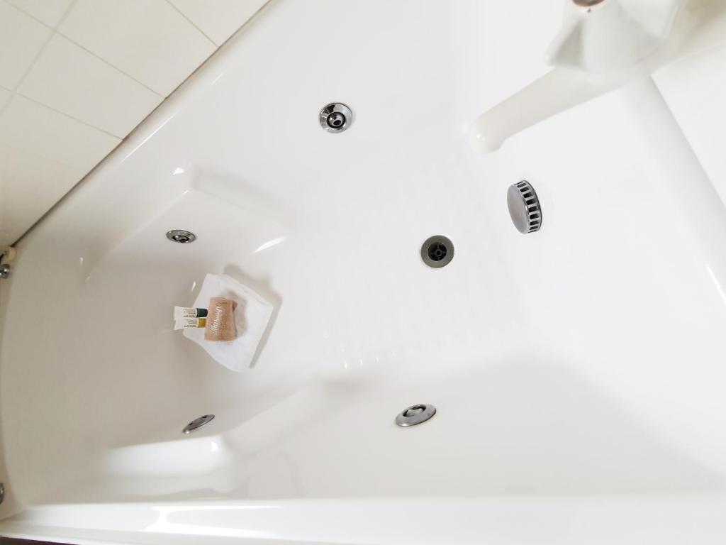 a bathroom with white walls and a glass wall at Fitzherbert Castle Motel in Palmerston North