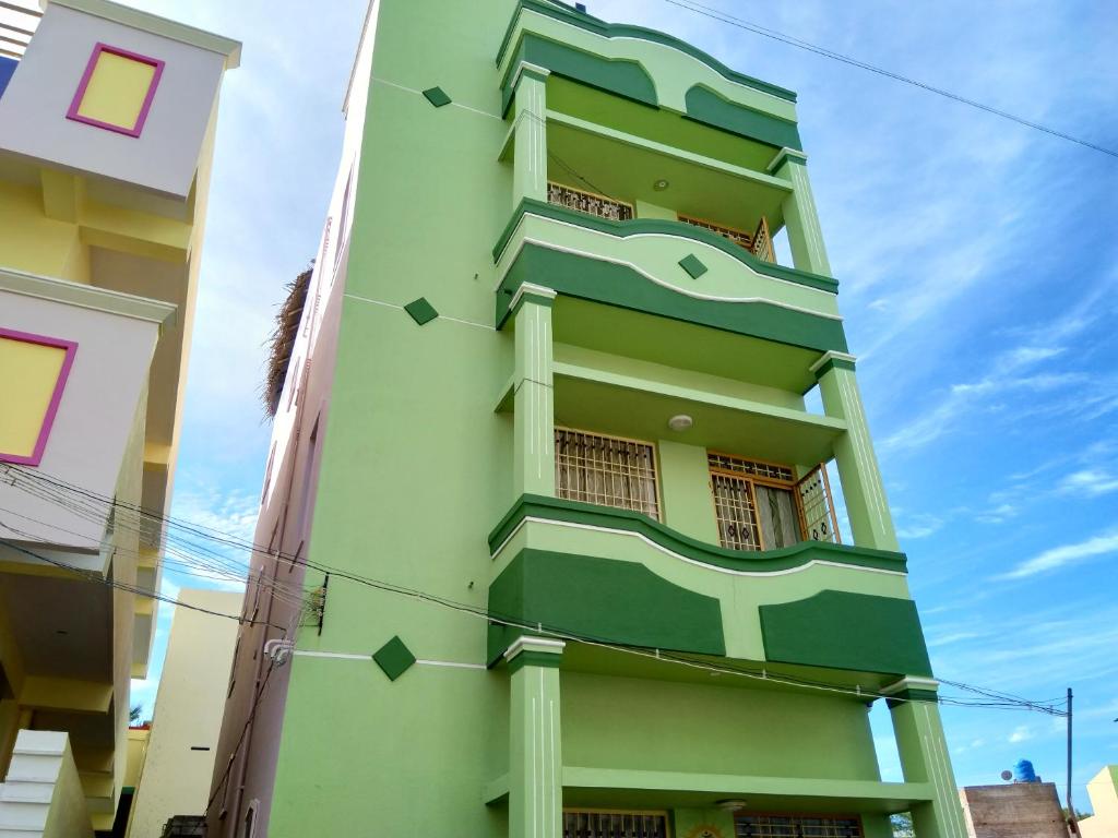 un edificio verde con delle frecce sopra di Green house a Tiruvannāmalai