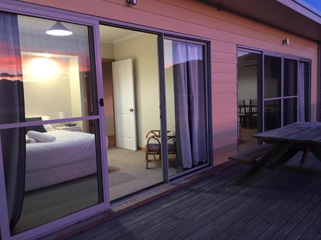 Cette chambre comprend un lit et un balcon avec des portes coulissantes en verre. dans l'établissement White Sands Estate unit 20, à Four Mile Creek