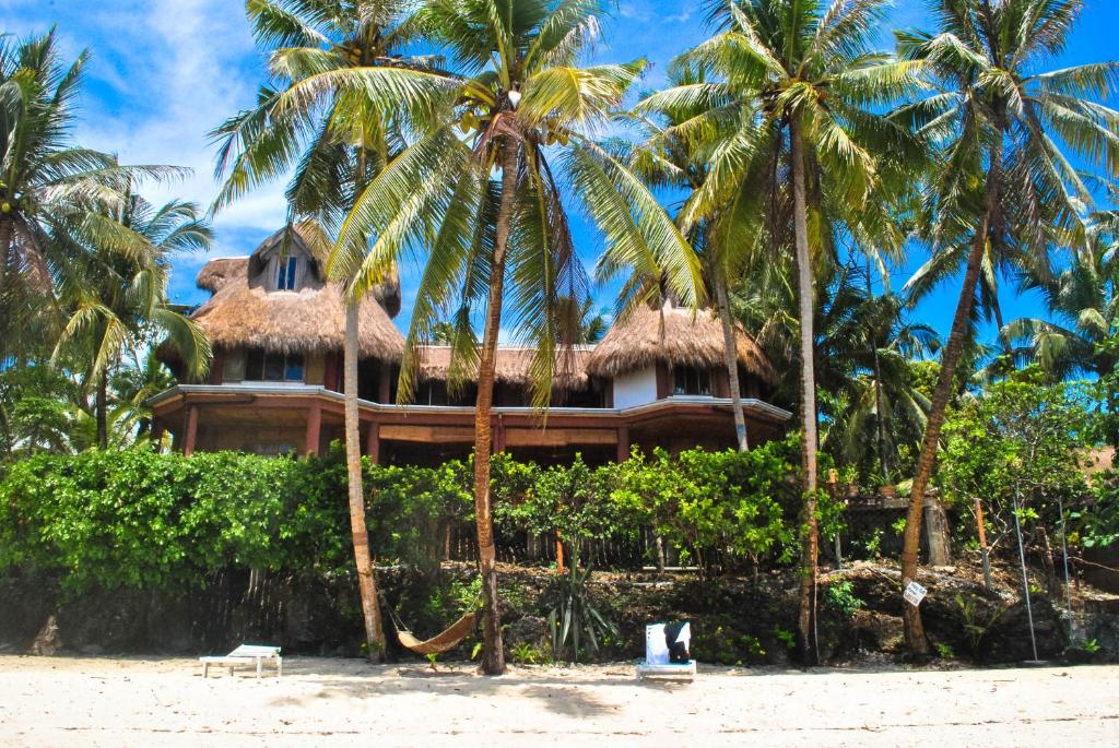 un resort sulla spiaggia con palme di VILLA MARMARINE BEACH RESORT & RESTAURANT a Siquijor