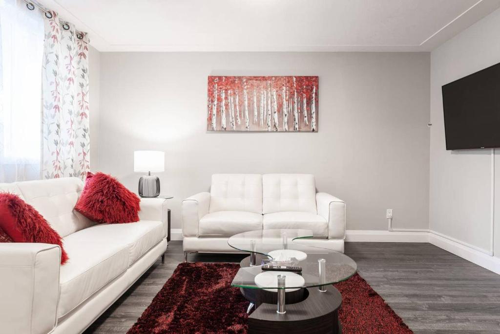 a living room with white furniture and a red rug at ENTIRE 2 BEDROOM APARTMENT UPTOWN WATERLOO - e1 in Waterloo