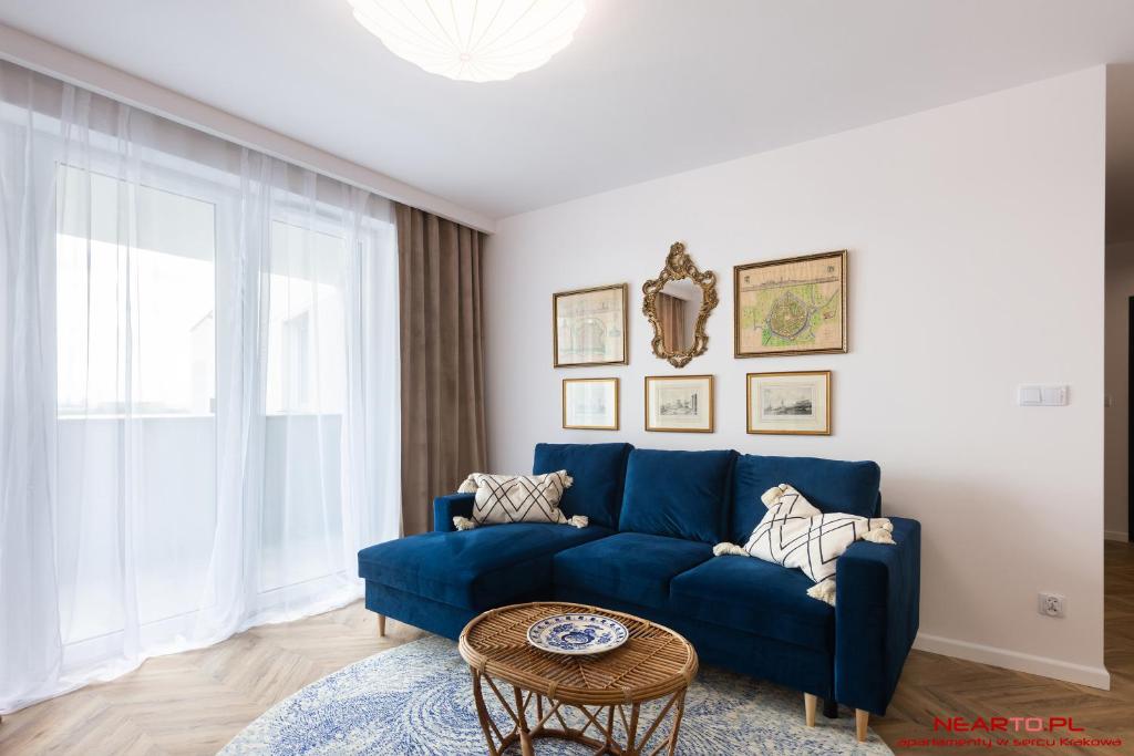 a blue couch in a living room with a table at Apartments Nearto Old Town Vermelo in Krakow