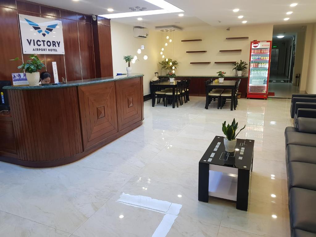a lobby with a waiting area with tables and chairs at Victory Airport Hotel in Ho Chi Minh City