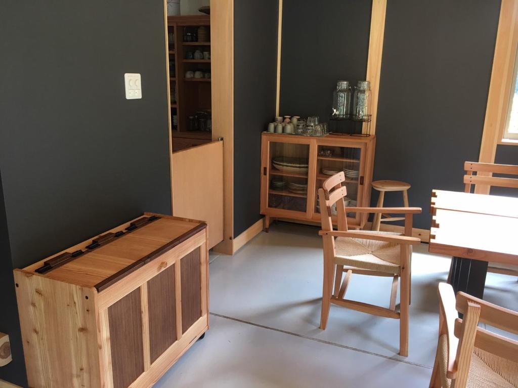 Habitación con caja de madera y silla en Guesthouse Kazenowa, en Asahi