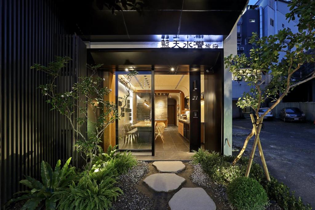 uma passagem que conduz a um edifício com plantas em Sun Moon Lake Blue Sky Bay B&B em Yuchi