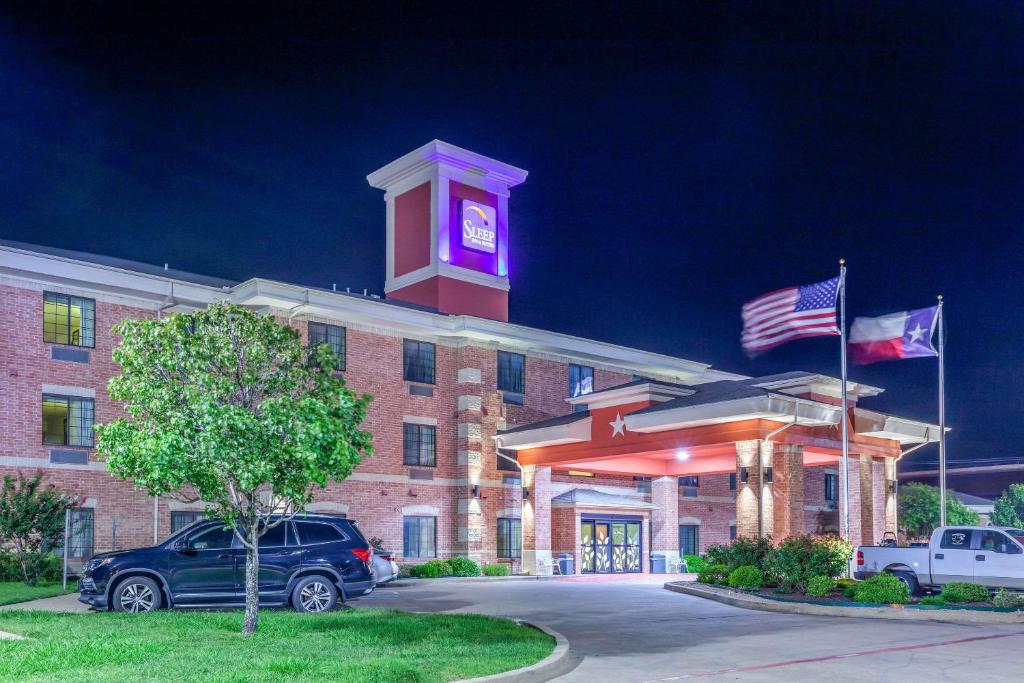 ein Hotel mit einem Uhrturm darüber in der Unterkunft Sleep Inn & Suites Hewitt - South Waco in Hewitt