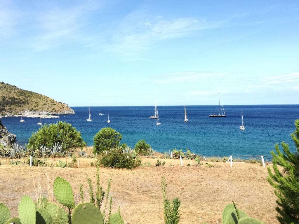 a view of the ocean from a beach with sailboats at Palinuro Romantic panoramico al centro del paese in Palinuro