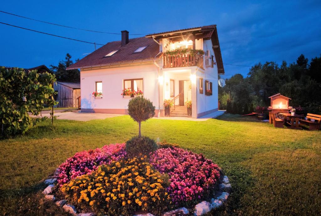 ein Haus mit einem Blumengarten davor in der Unterkunft Apartments Anna & Mateo in Rakovica
