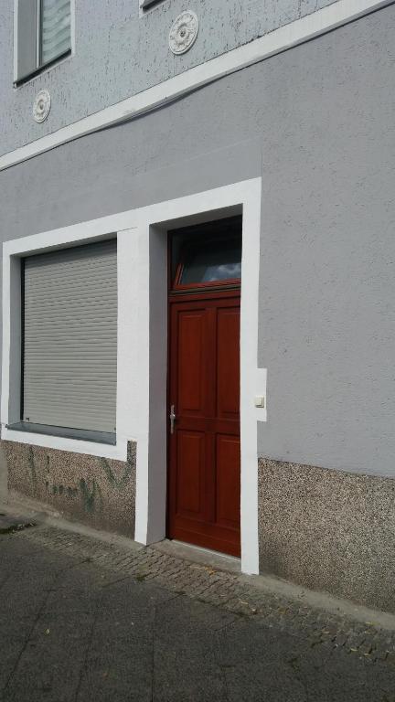 eine rote Tür an der Seite eines Gebäudes in der Unterkunft Ferienwohnung 3 in Berlin
