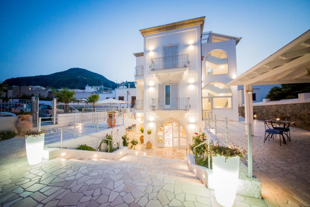 Un grand bâtiment blanc avec des lumières sur lui dans l'établissement Odysseus Hotel, à Lipari