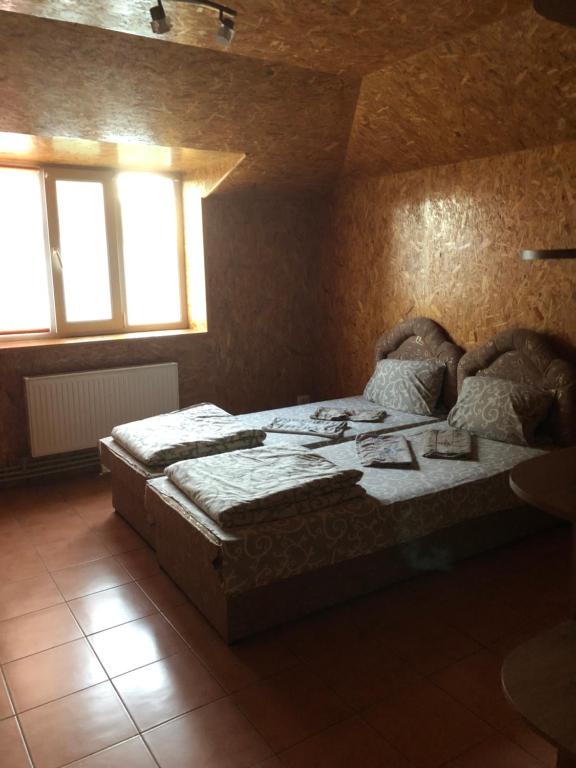 a bedroom with two beds and two windows at Кафе-бар «у Дідуся» in Vil'khy