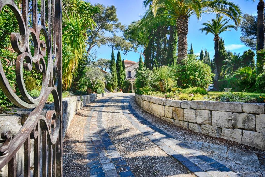 a gate to a driveway with palm trees and a house at Les Bastidieres - Cap Brun in Toulon
