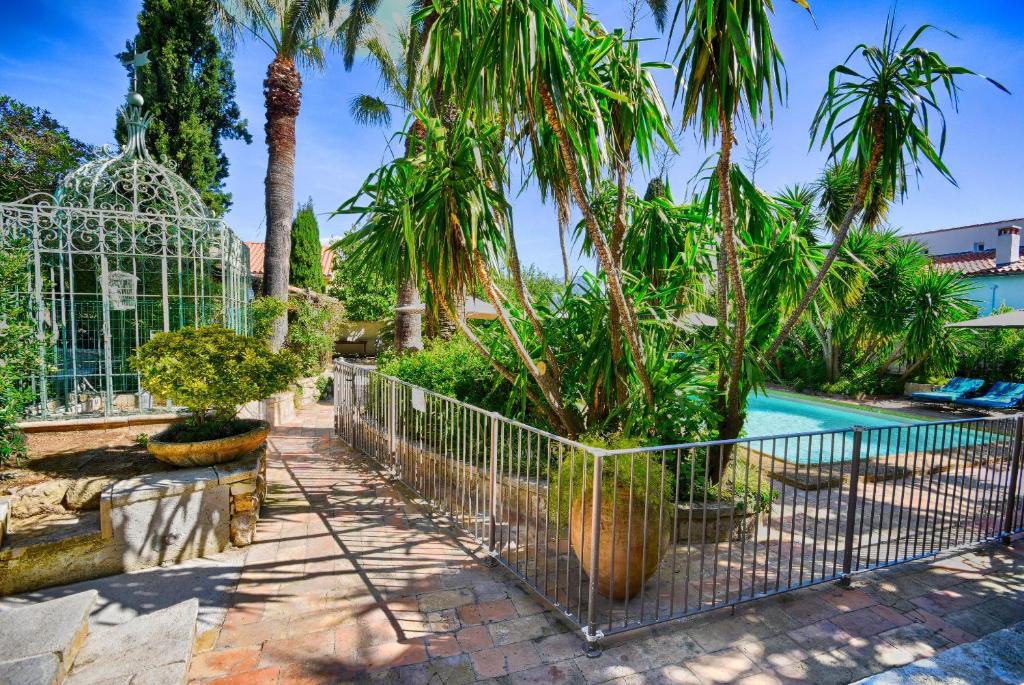 a villa with a swimming pool and palm trees at Les Bastidieres - Cap Brun in Toulon