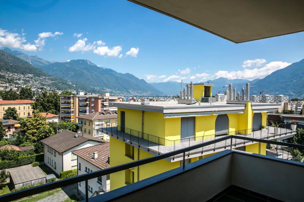 una vista dal balcone di un edificio giallo di Schöne Ferienwohnung mit Panoramablick a Locarno