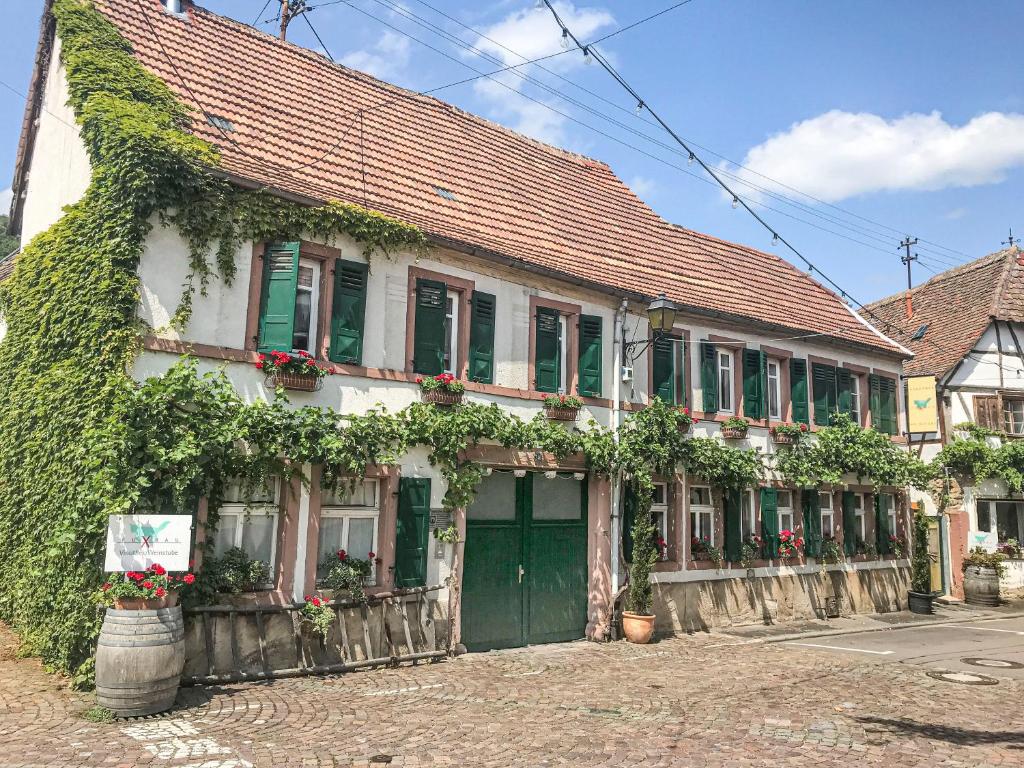 Cette maison ancienne est dotée de portes vertes et de lierre. dans l'établissement Fuxbau, à Neustadt an der Weinstraße