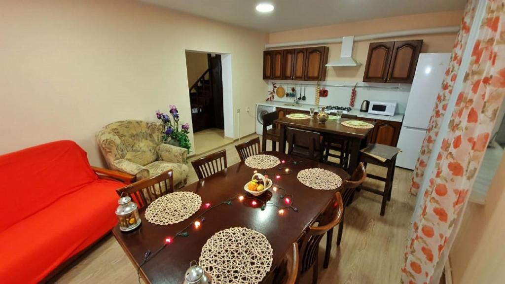 スタヴロポリにあるАпартаменты на Сероваのリビングルーム、キッチン(テーブル、赤いソファ付)