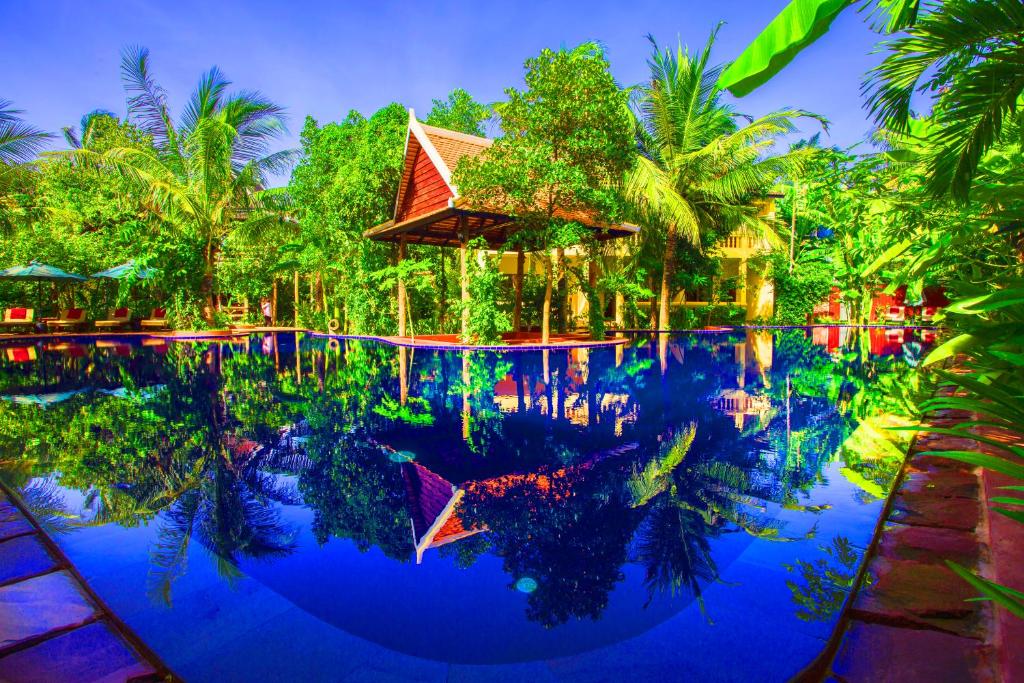 a pool at a resort with trees in the background at Le Jardin d'Angkor Hotel & Resort in Siem Reap