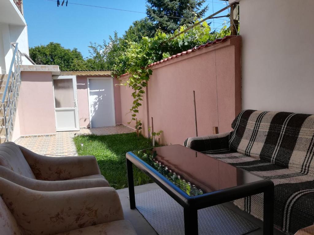 een patio met 2 stoelen en een salontafel bij Guest House Krasi in Ovoshtnik