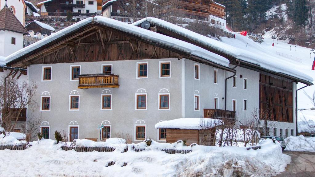uma grande casa branca com neve em cima em Paulnhof em Brennero