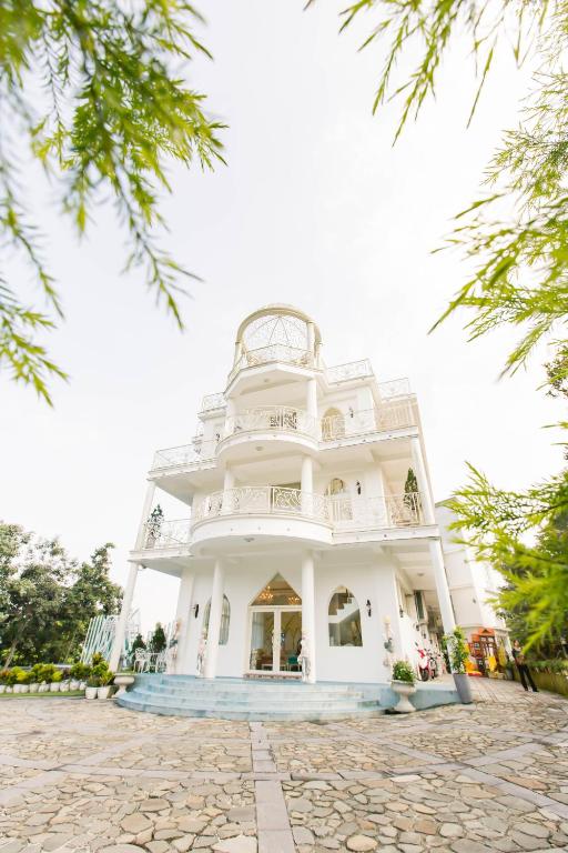 a large white building with a balcony at Bliss Bed and Breakfast in Yuchi