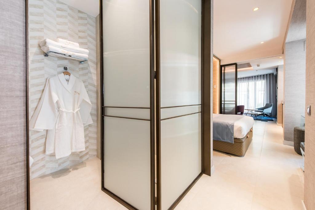 a dressing room with a white robe on a rack at The Garden Suites in Madrid