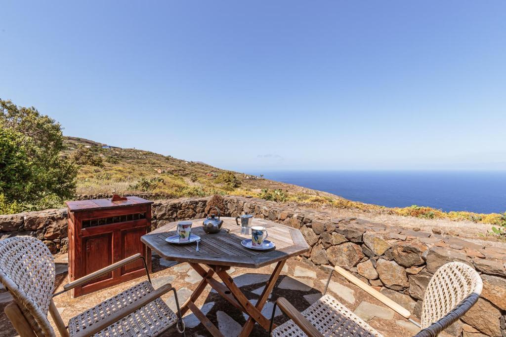 una mesa y sillas en un patio con vistas al océano en Los Hondos, en Garafía