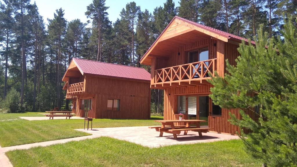 une grande cabane en bois avec bancs dans un parc dans l'établissement Brīvdienu māja INESE, à Bernāti