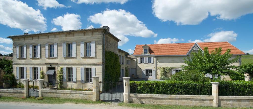 uma casa velha com uma cerca em frente em Clos 1906 em Saint-Émilion