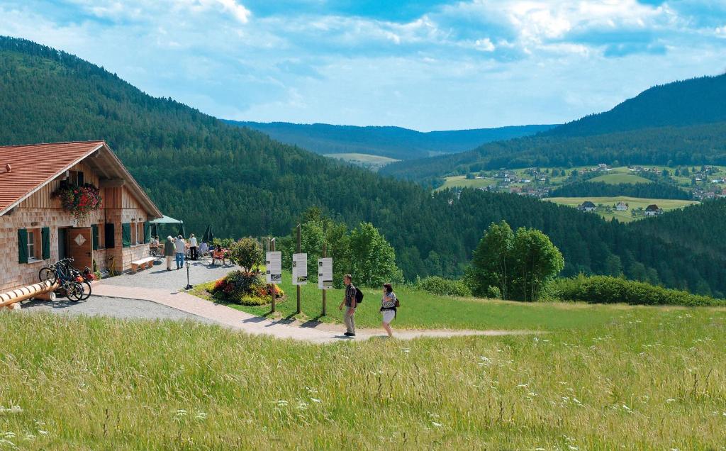 dos personas caminando por un camino cerca de un edificio en Sackmanns Wanderhotel Löwen, en Baiersbronn