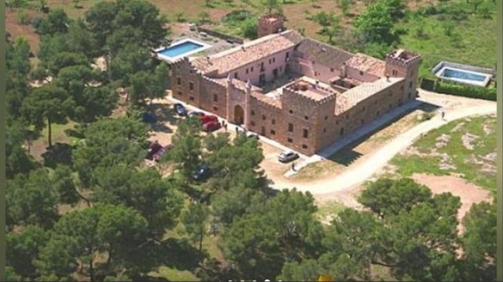 an aerial view of a large brick house with trees at Castillo con piscina en plena Sierra Calderona in Segorbe