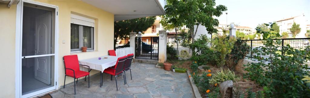patio z białym stołem i czerwonymi krzesłami w obiekcie Thesshouse Pefka FK w Salonikach