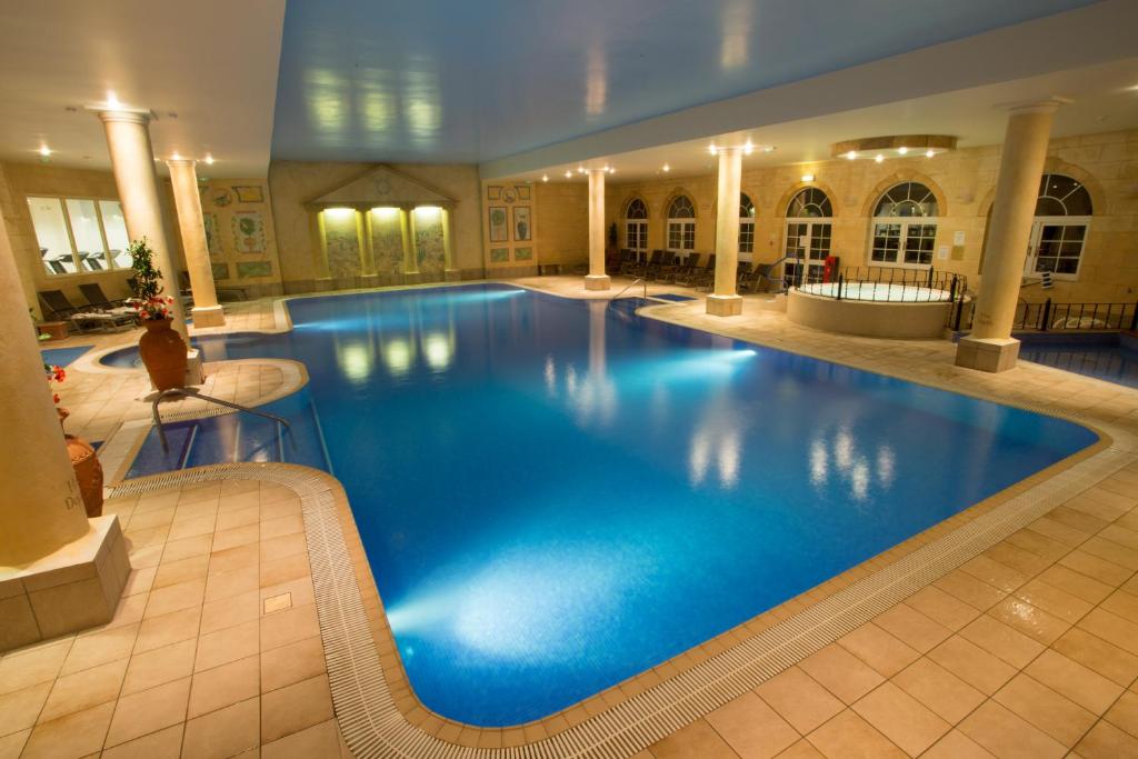 a large blue swimming pool in a hotel at Sketchley Grange Hotel in Hinckley