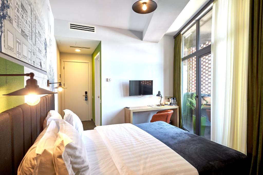 Postel nebo postele na pokoji v ubytování Graphica Tbilisi Hotel
