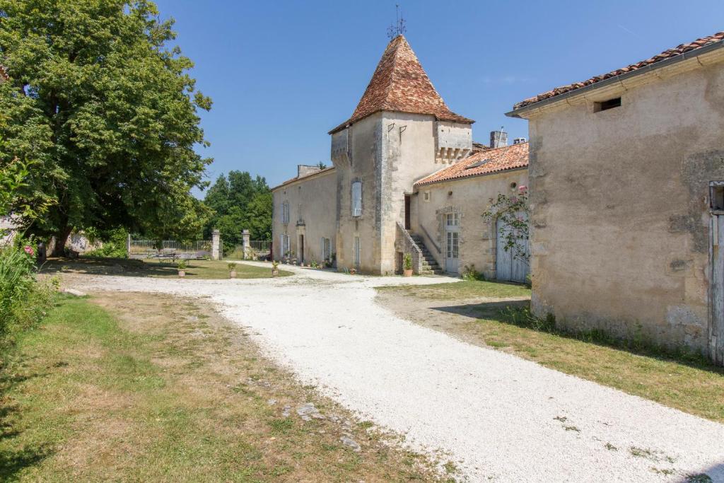 an empty road in front of an old building at Château de La Combe in Puyrenier