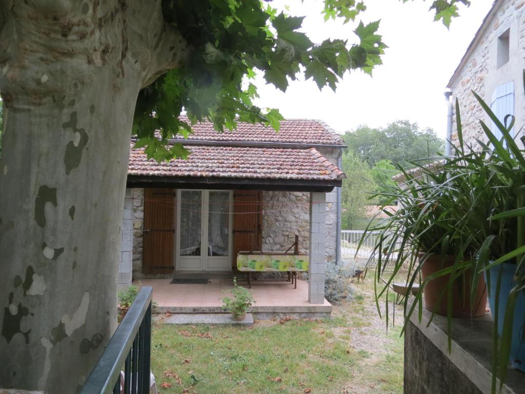 une petite maison avec un banc dans la cour dans l'établissement gite des trouilleres minimum 7nuits, à Sampzon