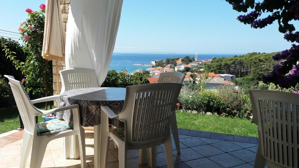 a table and chairs on a patio with a view of the ocean at Guest House Lucija in Rab