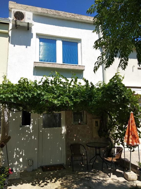 a patio with a table and chairs and a building at Kuća za odmor Matko House Matko in Pag