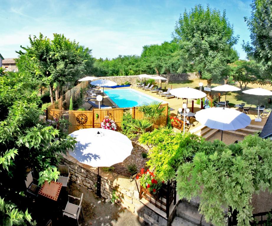 een uitzicht over een zwembad met parasols bij Hôtel Restaurant Le Relais des Gourmands in Gramat