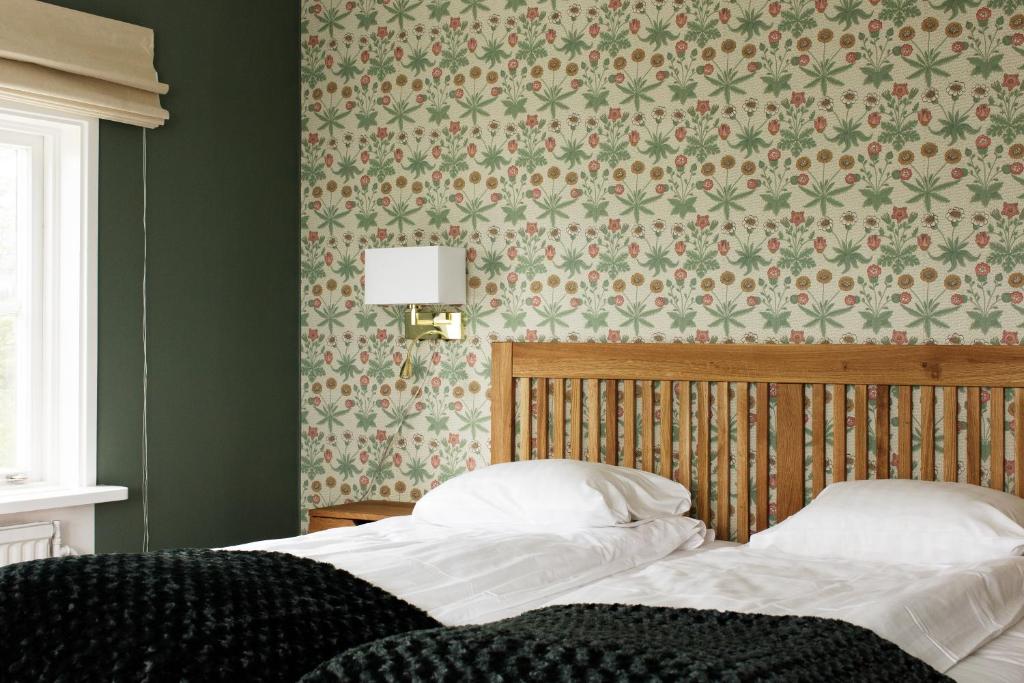 A bed or beds in a room at Hotel Kallgården
