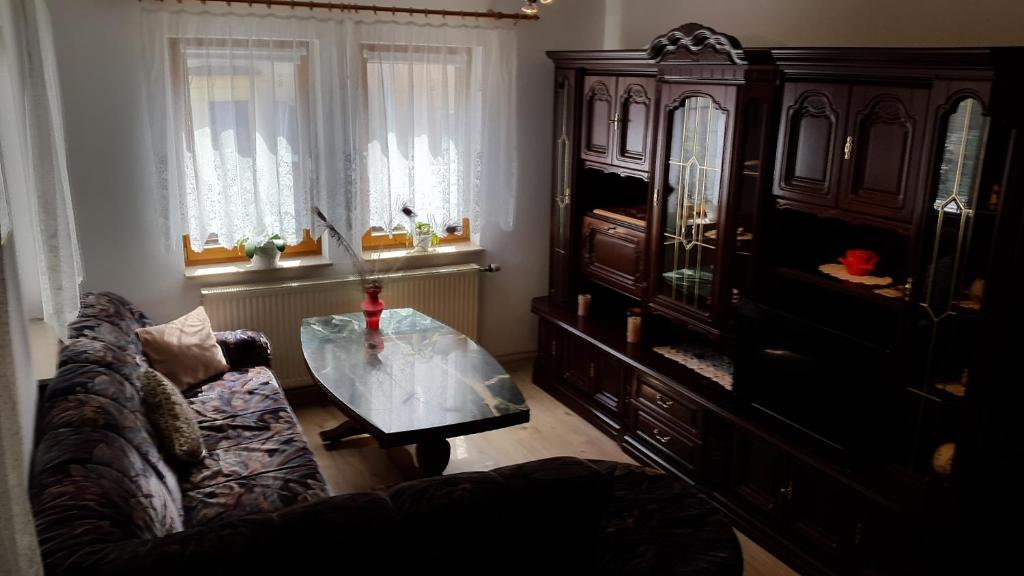 een woonkamer met een bank en een glazen tafel bij Ferienwohnung Schlothauer 1 in Ruhla