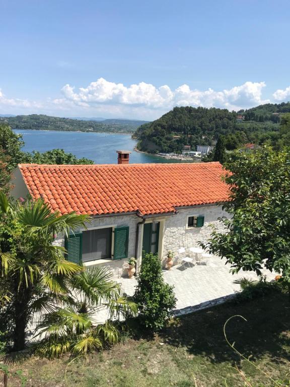 ein Haus mit einem orangenen Dach und einem Wasserkörper in der Unterkunft Guest house - počitniška hiška v Fiesi, Piran in Piran