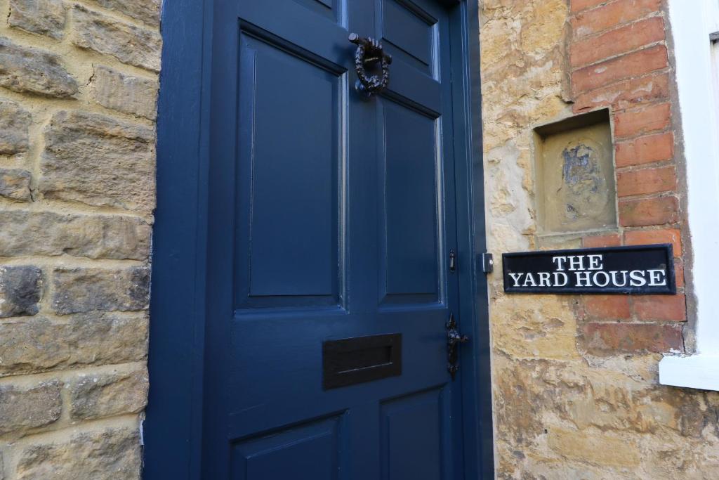 una puerta azul con un cartel en la casa del patio en The Yard House, en Sherborne