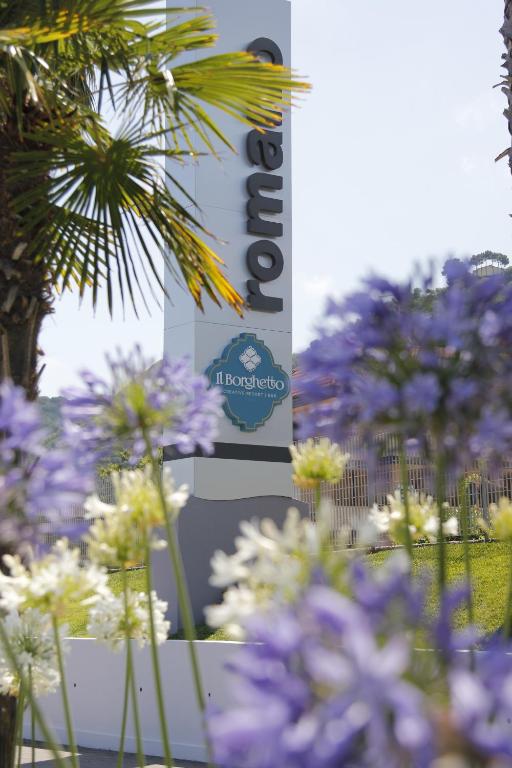 a bunch of purple flowers in front of a sign at Il Borghetto Resort & Spa in Tropea