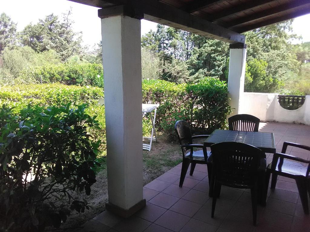 a patio with a table and chairs on a porch at White Sand Residence in Murta Maria