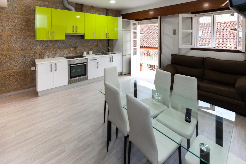kuchnia i salon ze szklanym stołem i krzesłami w obiekcie Duplex Familiar w mieście Ribadavia