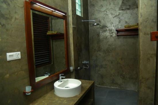 a bathroom with a sink and a mirror at Goyambokka Guesthouse in Tangalle