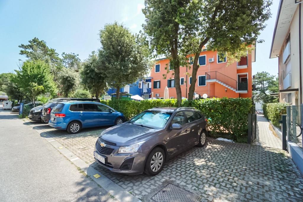 um par de carros estacionados num parque de estacionamento em Villa Veneta em Bibione