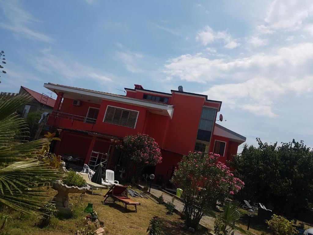 czerwony dom z ogrodem przed nim w obiekcie Villa DonnAnna w mieście Cariati